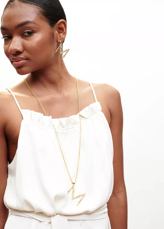 Long gold plated necklace featuring an M